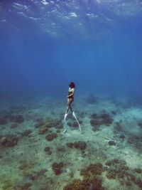 Rear view of woman swimming in sea