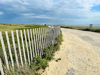 Wooden fence on field against sky