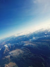 Aerial view of mountains against blue sky