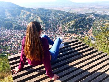 Woman looking at cityscape while sitting outdoors