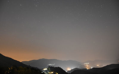 Low angle view of silhouette mountains against sky at night