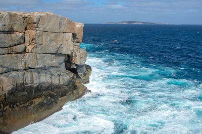 Rock formation in sea against sky