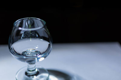 Close-up of wineglass on table against black background