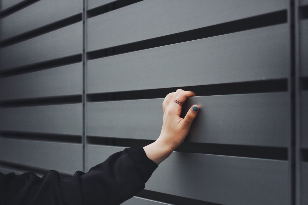 person, indoors, part of, personal perspective, cropped, human finger, lifestyles, holding, unrecognizable person, leisure activity, men, window, railing, one man only, close-up, wall - building feature