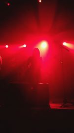 Silhouette woman standing in illuminated nightclub