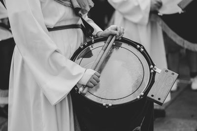 Midsection of person playing drum at parade