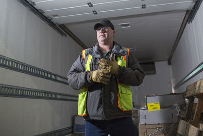 Worker looking away while standing in warehouse