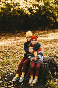 Portrait of smiling boy and woman in park