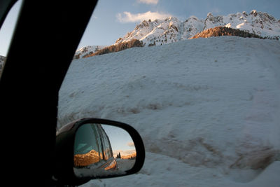 Snow covered car on mountain against sky