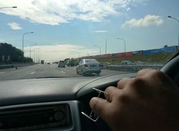 Man driving car on road against sky