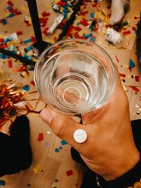 High angle view of hand holding beer glass on table