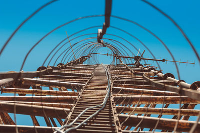 Low angle view of metal against blue sky