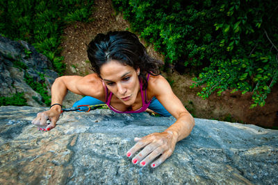 High angle view of woman climbing on rock