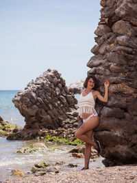 Woman standing on rock at sea shore