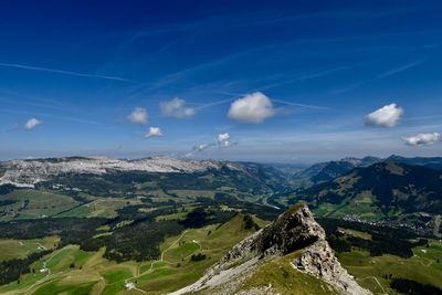 Aerial view of landscape and mountains against blue sky