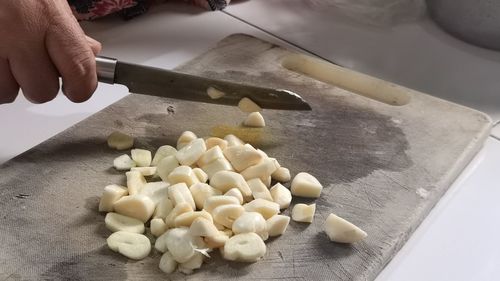 The cook cutting and dice garlic on a cutting board. preparation for cooking. slice garlic