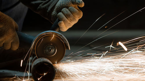 Cropped hands of man cutting metal in workshop