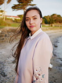 Portrait of beautiful young woman standing at beach