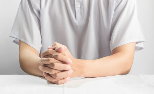 Midsection of woman sitting on bed