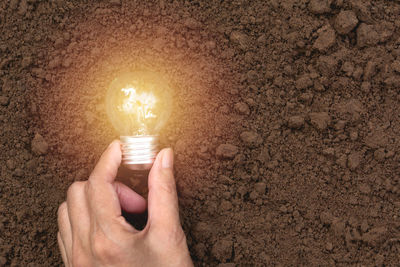 Close-up of hand holding light bulb