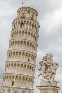 Leaning tower of pisa and statue against sky