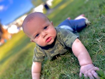 Portrait of cute boy sitting on grass