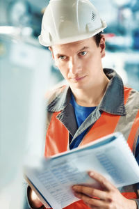 Man wearing hardhat examining in factory