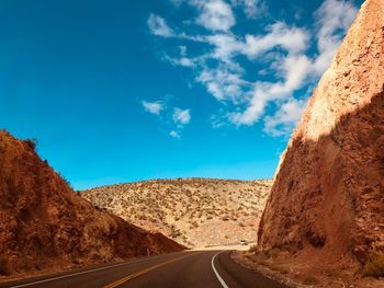 Road by mountain against blue sky