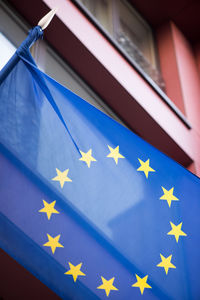 Close-up of flags against blue wall