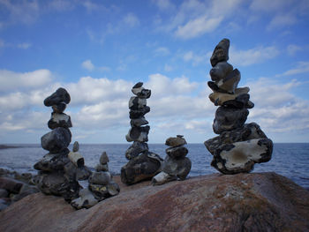 Stack of stones in sea against sky