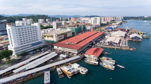 High angle view of cityscape by sea against sky