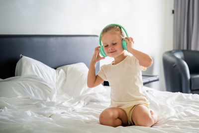 Portrait of cute girl playing on bed at home