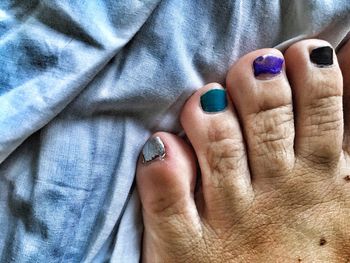 Low section of woman with colorful nail polish on textile