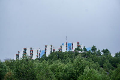 Low angle view of trees and buildings against sky