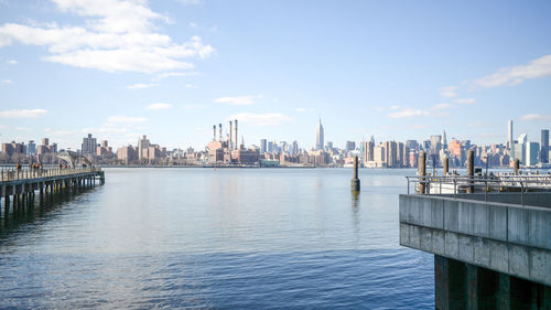 Scenic view of lake and cityscape against sky