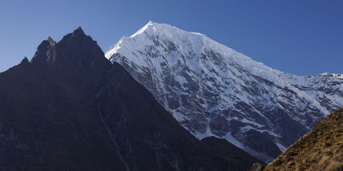 Scenic view of snowcapped mountains against clear sky