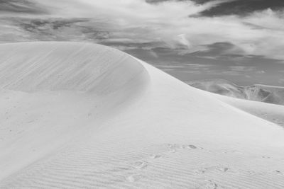 Sand dunes in desert against sky