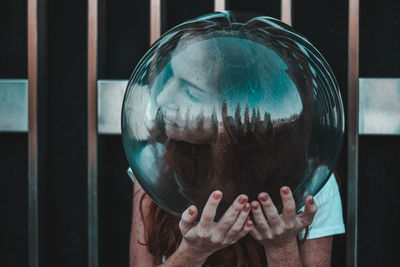 Close-up of young woman wearing glass helmet in head against metallic railing