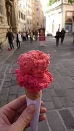 Midsection of person holding ice cream on street