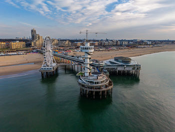 Aerial view of coastal pier with spiral observation tower, ferris wheel, and dome structure framed