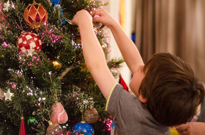 Close-up of boy hanging on christmas tree