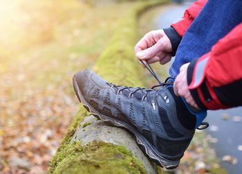 Low section of man tying shoelace