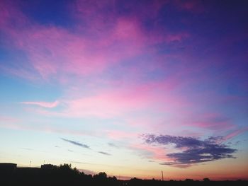 Low angle view of silhouette trees against sky