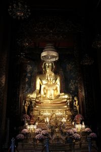 Statue against illuminated building