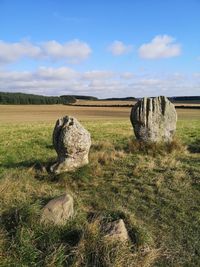 Hay bales on field against sky