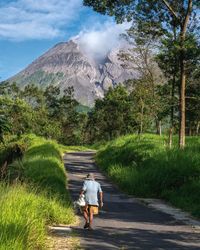 Rear view of man walking on road