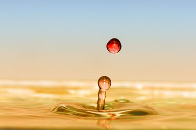 Close-up of water splashing in sea against sky