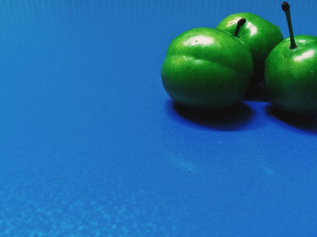 fruit, food and drink, healthy eating, green color, freshness, food, still life, close-up, blue, indoors, copy space, studio shot, no people, table, green, organic, apple, ripe, grape, ball