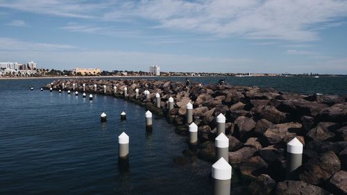 Flock of birds by sea against sky