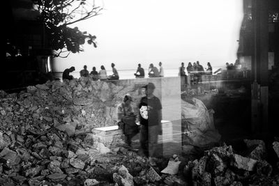 People on shore against clear sky